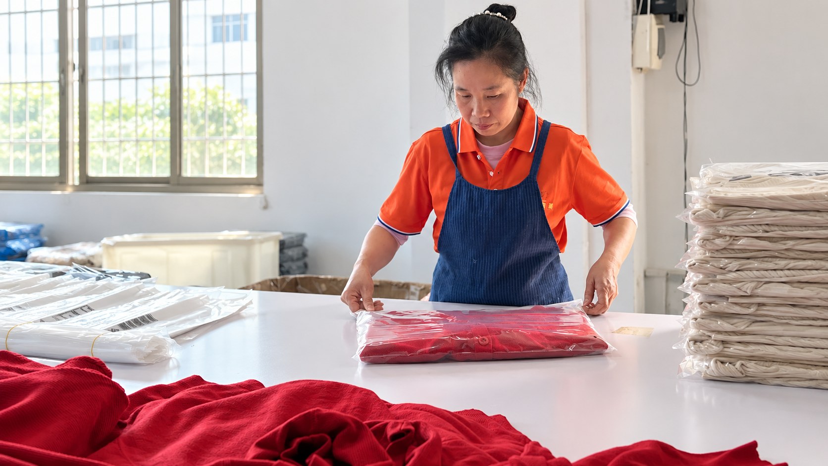 A Wayhonk team member preparing a knitted garment for packing.