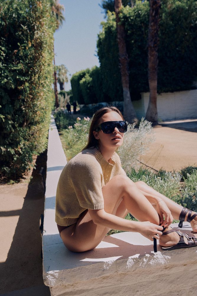 Beige knit top styled outdoors, alternate view.