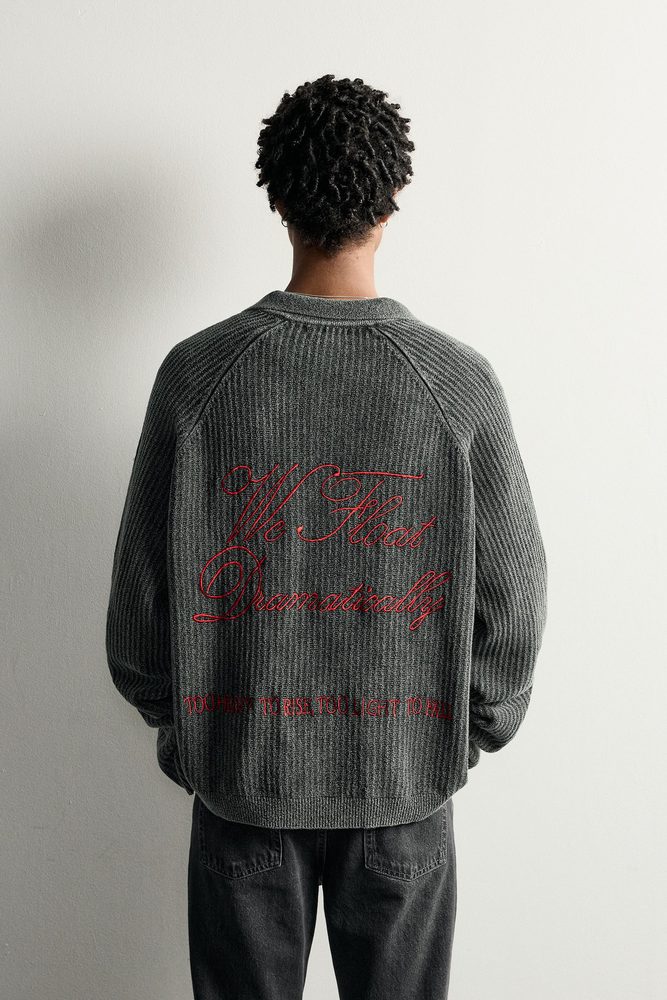 Dark collared knit shirt, back view.