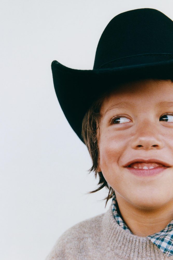 Child wearing a taupe sweater, close-up.