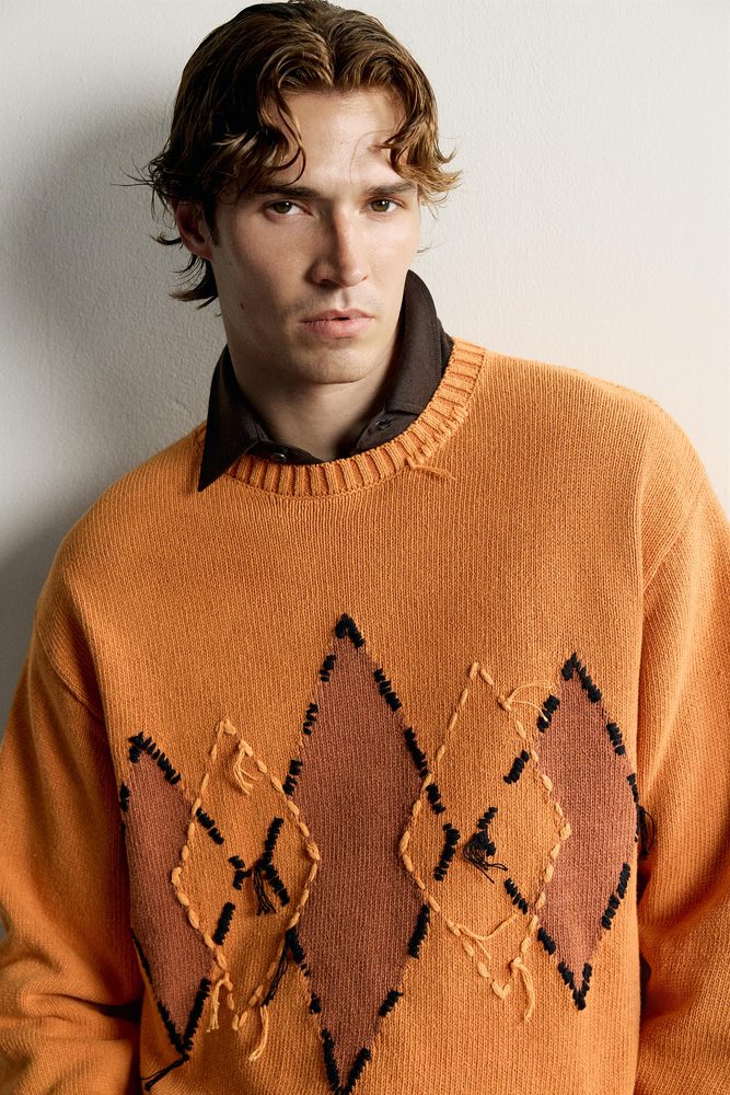 Orange diamond-pattern sweater detail.