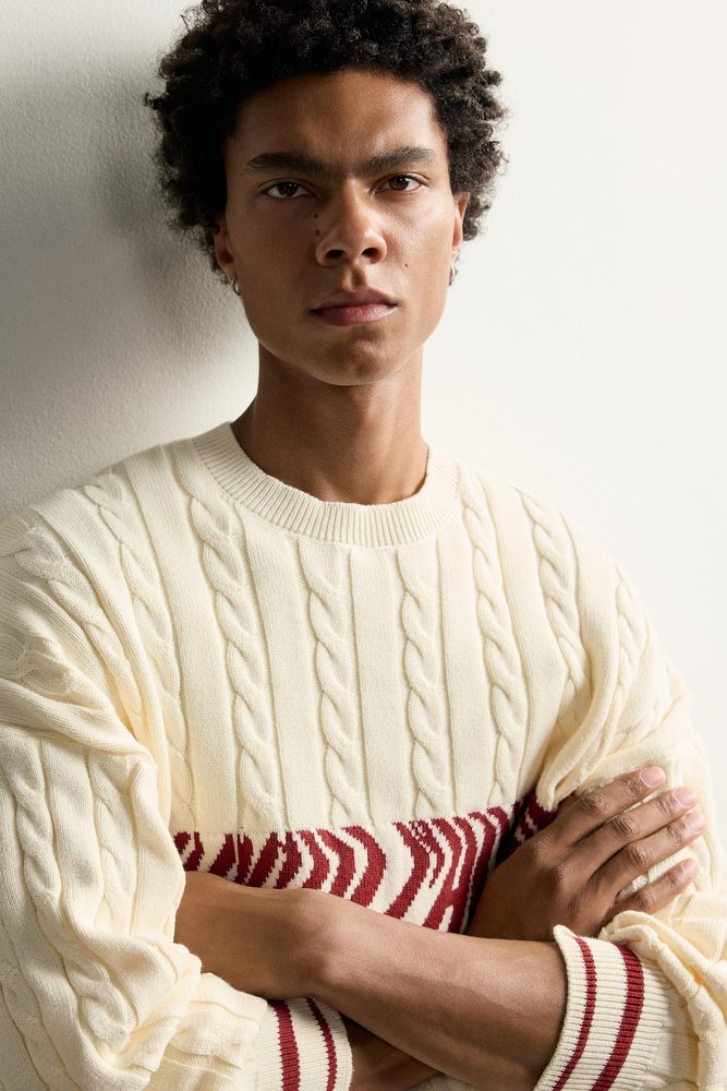 Cream cable sweater, close-up of knit structure.