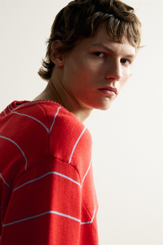 Red striped knit polo, shoulder detail.