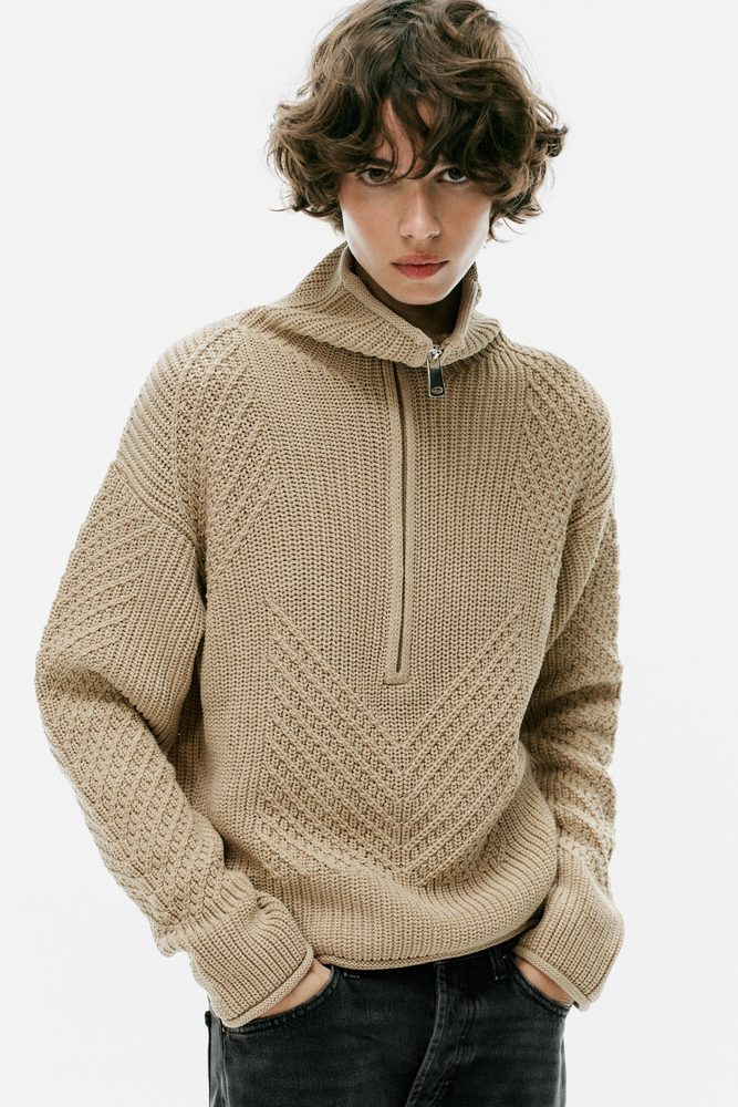 Beige textured quarter-zip knit sweater.