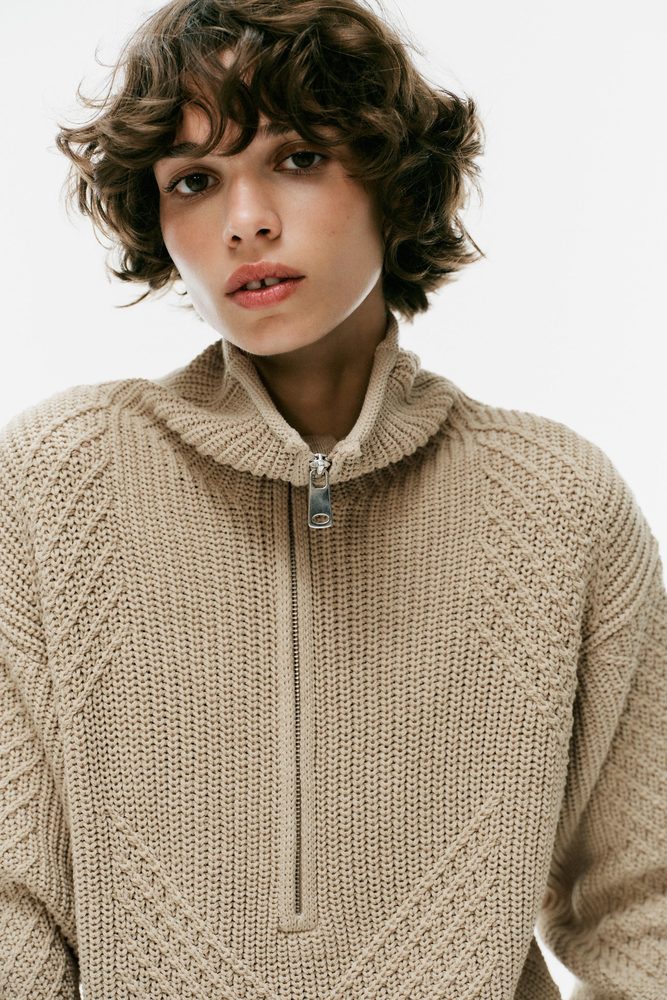 Beige quarter-zip sweater, shoulder and stitch detail.