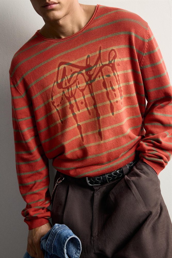 Red sweater with contrasting graphic lines, close-up.