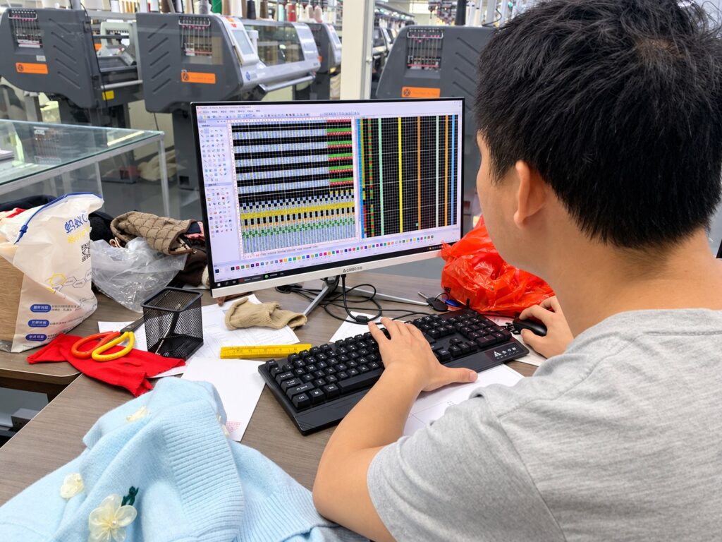 A Wayhonk team member developing a knit pattern at a computer.
