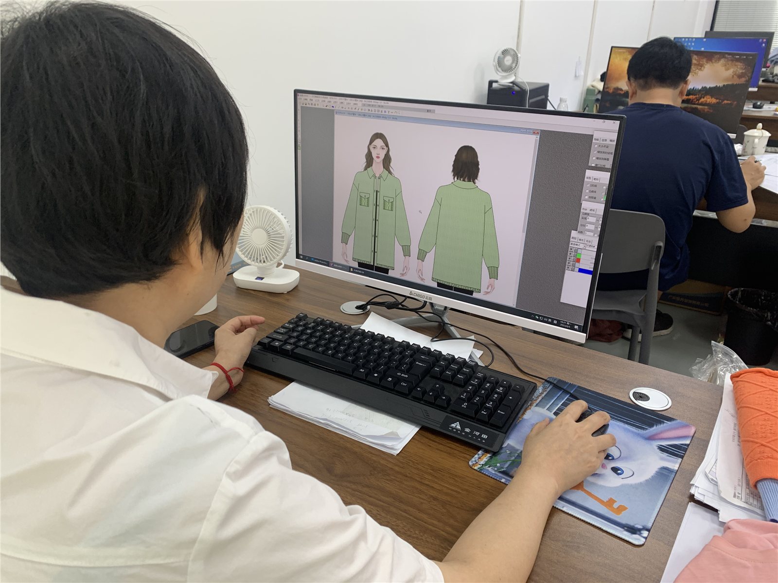 A team member reviewing garment design views on a screen.