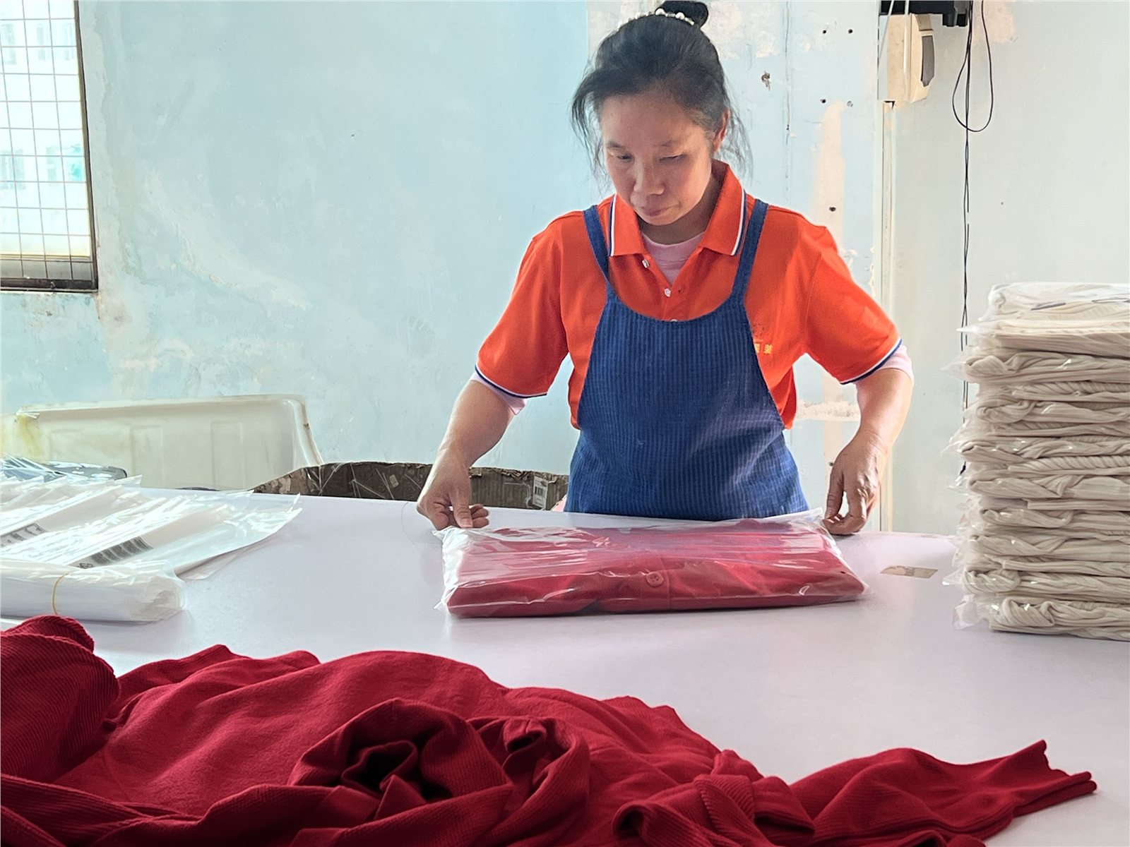 A team member folding and individually packing a knit garment.