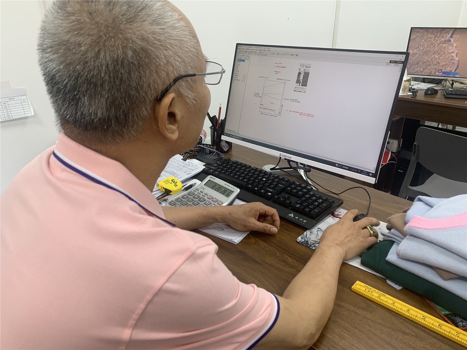 A team member planning a garment outline and measurements on a screen.
